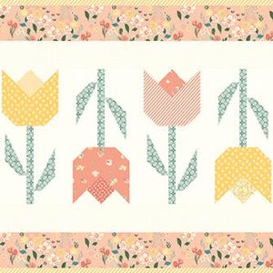 May include: A rectangular quilt featuring seven stylized tulip flowers in shades of peach, yellow, and pink. The tulips have green stems and leaves, set against a cream background. The border is a floral pattern in peach and cream.