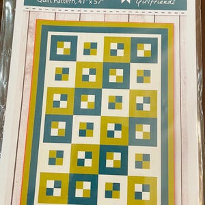 May include: A quilt pattern called "3YD Alpha" by Material Girlfriends. The pattern is for a quilt measuring 41 inches by 57 inches. The quilt design features a grid of squares in shades of teal, white, and yellow.