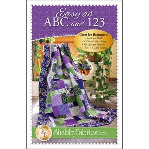 May include: A quilt pattern titled "Easy as ABC and 123" with a purple floral design. The quilt is draped over a chair, showcasing a patchwork design in shades of purple, green, and white. The pattern is "Great for Beginners!" and includes six sizes.
