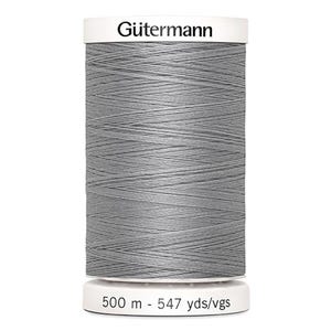 May include: A spool of Gütermann gray thread. The thread is tightly wound on a white spool. The spool has the Gütermann logo and the text "500 m - 547 yds/vgs" printed on it. The thread is a medium gray color.
