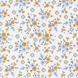 May include: White fabric with a repeating floral pattern. The design features clusters of yellow and light blue flowers with dark blue stems and small cross-stitch-like accents. The overall effect is a delicate, vintage-inspired print.