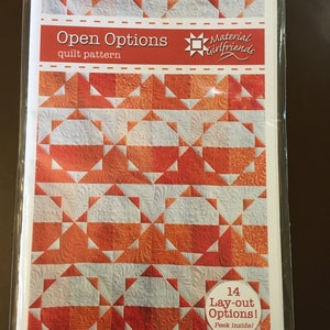 May include: A quilt pattern booklet with a red, orange, and white quilt design on the cover. The title of the pattern is "Open Options" and the booklet is from "Material Girlfriends". The cover also states that there are 14 lay-out options and encourages the viewer to "Peek inside!"
