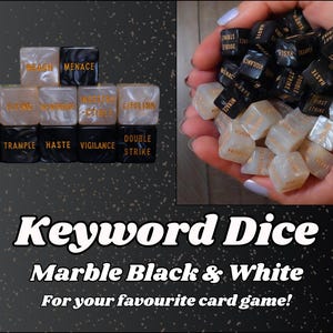 Op de afbeelding: Zwarte en witte dobbelstenen in marmerstijl met gouden letters, met trefwoorden zoals "Menace" en "Vigilance". De afbeelding bevat de tekst "Keyword Dice" en "Marble Black & White" voor kaartspellen.