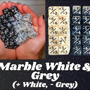 Puede incluir: Dados con textura de mármol en blanco y gris, con numeración negra. Los dados se muestran en las manos de una persona y apilados. La imagen incluye el texto "Marble White & Grey (+ White, - Grey)".