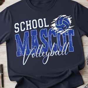 K&ouml;nnte beinhalten: Marineblaues T-Shirt mit den Worten "SCHOOL MASCOT Volleyball" in Wei&szlig; und Blau. Eine blaue Volleyball-Grafik befindet sich &uuml;ber dem Wort "MASCOT". Das Shirt besteht aus einem weichen, bequemen Material.
