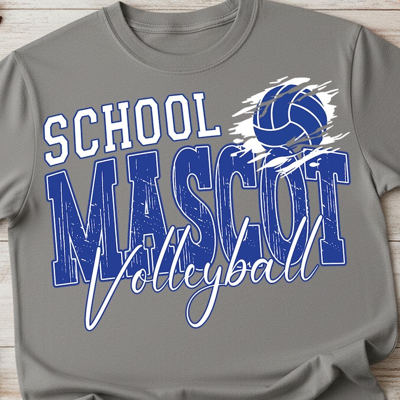 K&ouml;nnte beinhalten: Graues T-Shirt mit einem blau-wei&szlig;en Volleyball-Grafik. Das Shirt zeigt die Worte "SCHOOL MASCOT Volleyball" in einer kr&auml;ftigen, verwitterten Schriftart. Ein blauer Volleyball befindet sich oben rechts.