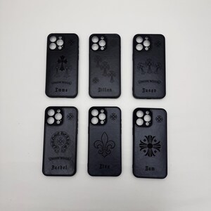 Pu&ograve; includere: Sei custodie nere per telefono con vari disegni in rilievo, tra cui croci, gigli e un emblema circolare. Ogni custodia ha un nome inciso in basso: Emma, Dillon, Susan, Rachel, Elsa e Sam.