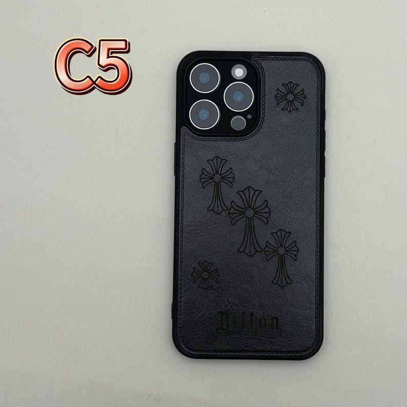 May include: Black phone case with a cross design. The case has a black border and a textured back with embossed crosses and the word "Dillon". The case also has a camera cutout and the text "C5" in a red and orange font.