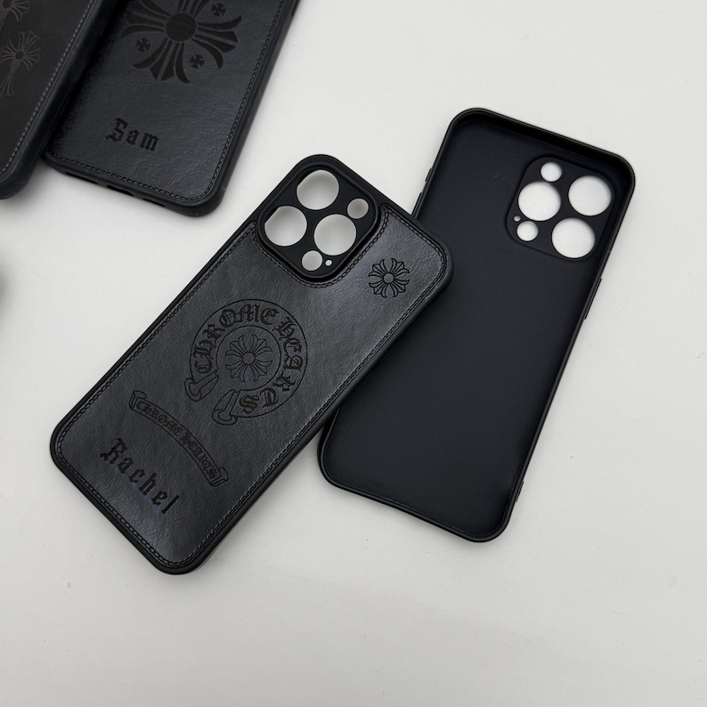 Pu&ograve; includere: Custodie per telefono in pelle nera con disegni in rilievo. Una custodia presenta il testo "Chrome Hearts" e il nome "Rachel". Un'altra custodia ha il nome "Sam". Le custodie hanno un design a croce e floreale.