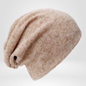 May include: A beige slouchy beanie hat with a textured knit pattern. The hat is made of a soft, lightweight material and has a relaxed fit. The color is a neutral tone, suitable for various outfits.