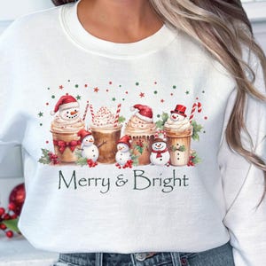 Festive Christmas Sweatshirt Coffee Cup Design Holiday Apparel Collection Merry Bright Saying Snowman Whipped Topping Holly Berry Decoration Candy Cane Accent Winter Seasonal Wear Comfortable Cotton Blend Multiple Size Options Holiday Party