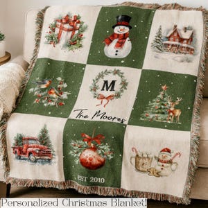 May include: A personalized Christmas blanket with a patchwork design featuring Christmas-themed illustrations. The blanket has a green and cream color scheme, with images of a snowman, a red truck, and a Christmas tree. The text "The Moores" and "EST 2010" are also visible.
