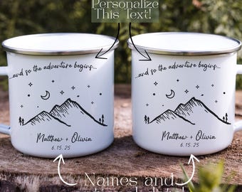 May include: Two white enamel mugs with a silver rim, featuring a mountain and stars design. The text reads "...and so the adventure begins..." with the names "Matthew + Olivia" and the date "6.15.25".