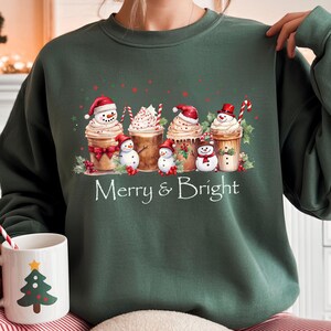 Christmas Coffee Design Festive Seasonal Apparel Merry Bright Theme Snowman Cup Illustration Whipped Cream Detail Candy Cane Accent Holly Berry Decoration Comfortable Cotton Blend Perfect Christmas Gift Holiday Winter Holiday Sweatshirt