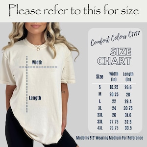 May include: Cream-colored t-shirt with a size chart, including width and length measurements in inches. The chart lists sizes S through 4XL. The text "Please refer to this for size" is at the top. The model is wearing a medium.