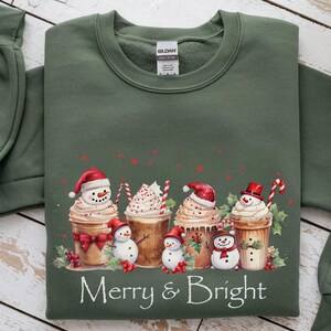 Christmas Coffee Sweatshirt Holiday Design Festive Apparel Merry Bright Winter Clothing Seasonal Wear Christmas Outfit Snowman Cup Whipped Cream Design Holly Berries Candy Canes Red Green Stars Cotton Blend Comfort Casual Holiday Style