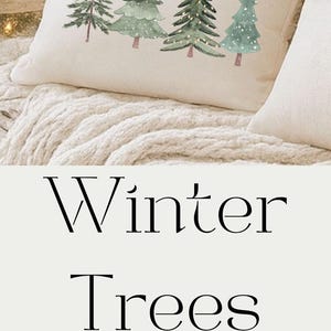 May include: White rectangular pillow with a watercolor design of green Christmas trees. The pillow is on a bed with a white blanket. The text "Winter Trees Decor" is in the image.