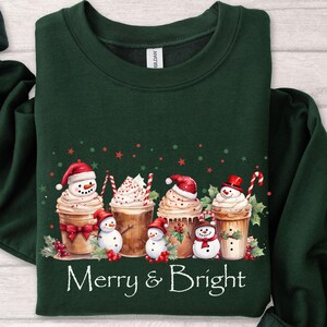 Winter Holiday Sweatshirt Christmas Coffee Design Festive Seasonal Apparel Merry Bright Theme Snowman Cup Illustration Whipped Cream Detail Candy Cane Accent Holly Berry Decoration Comfortable Cotton Blend Perfect Christmas Gift Holiday