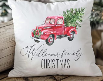 May include: White square throw pillow featuring a watercolor illustration of a red vintage truck carrying a Christmas tree. The text "Williams family CHRISTMAS" is written in black script and block letters.