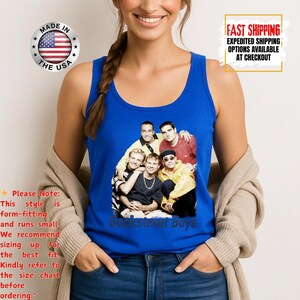May include: A blue tank top featuring a group photo of the Backstreet Boys. The tank top has a round neckline and is made of a soft material. The words "Backstreet Boys" are printed in a blue font at the bottom of the image.