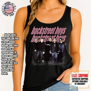 May include: Black tank top featuring the band Backstreet Boys in a group photo. The band's name is printed in pink, stylized text across the top. The tank top is form-fitting and runs small.