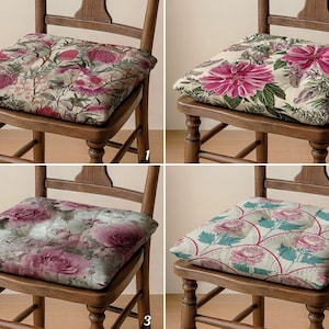 May include: Four wooden chairs, each with a different floral patterned seat cushion. The cushions feature various designs with pink and purple flowers, green leaves, and a cream background. The chairs are made of wood.