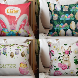 Peut inclure: Ensemble de quatre coussins sur le thème de Pâques. Les motifs comprennent un coussin rose avec des oreilles de lapin et des œufs de Pâques, un coussin vert foncé avec des œufs et des paniers de Pâques, un coussin blanc avec des œufs suspendus et un poussin, et un coussin blanc avec un lapin et des fleurs.