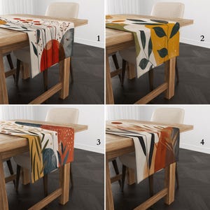 Peut inclure: Quatre chemins de table avec des motifs botaniques abstraits sont présentés sur des tables en bois. Chaque chemin de table présente une palette de couleurs différente, dont le rouge, l'orange, le jaune et le vert, avec des motifs de feuilles et de cercles. Les chemins de table sont rectangulaires et en tissu.