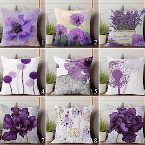 Op de afbeelding: Negen decoratieve sierkussens met bloemmotieven in paarse tinten. De kussens tonen verschillende bloemsoorten, waaronder anemonen, paardenbloemen en lavendel. Sommige kussens hebben aquareleffecten, terwijl andere gedetailleerde illustraties hebben. De kussens zijn vierkant.