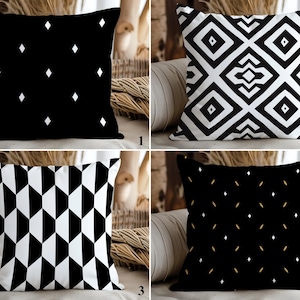 May include: Four decorative throw pillows with geometric patterns. The pillows feature black and white designs, including diamonds, geometric shapes, and a repeating pattern. The pillows are square and appear to be made of a soft fabric.