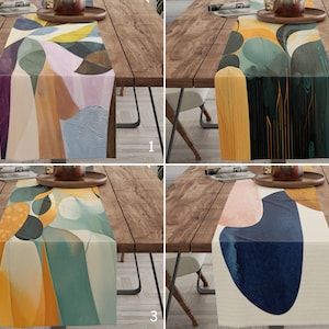 Puede incluir: Cuatro caminos de mesa abstractos con diseños coloridos se exhiben sobre una mesa de madera. Cada camino de mesa presenta un patrón único de formas y colores, incluyendo azules, verdes, naranjas y rosas. Los caminos de mesa son rectangulares.