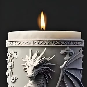 Może przedstawiać: Zapalone świeca w białym pojemniku z motywem smoka. Świeca ma żółty płomień. Pojemnik ma szczegółowy relief głowy smoka, skrzydeł i elementów dekoracyjnych. Tło jest ciemne.