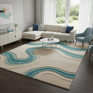 Pode incluir: Um tapete grande com um design ondulado em tons de bege e azul-petróleo. O tapete está em uma sala de estar com um sofá seccional branco, uma mesa de centro redonda e duas poltronas azuis. O quarto tem pisos de madeira e janelas grandes.