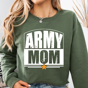 May include: An olive green sweatshirt with the words "ARMY MOM" in white block letters. A small orange star is below the text. The sweatshirt is a crew neck style.