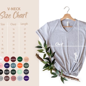 May include: A light gray V-neck t-shirt hanging on a wooden hanger. The image includes a size chart with chest and length measurements in inches, and a color chart with various options like white, red, and navy.