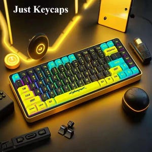 May include: A yellow and black mechanical keyboard with teal and yellow keycaps. The keyboard has a cyberpunk theme, with the word "Cyberpunk" printed on the spacebar. The image also includes the text "Just Keycaps".