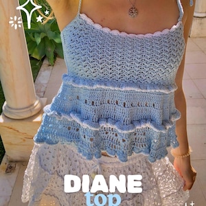 Puede incluir: Un top de ganchillo azul claro con ribete blanco y tirantes anudados. El top tiene un diseño con volantes y se combina con una falda de ganchillo blanca. El texto "DIANE top" y "BY THREADS AND KISSES" se muestran en la imagen.