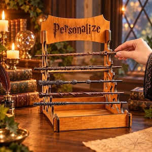 May include: A light brown wooden display stand with the word Personalize engraved at the top. The stand features five horizontal slots holding five distinct wands of varying brown and black tones, textures, and shapes, arranged in a tiered structure.