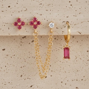 Op de afbeelding: Een set van drie keramische mokken met een gespikkelde, matte afwerking. De mokken zijn in de kleuren crème, lichtgrijs en donkergrijs. Elke mok heeft een eenvoudig, minimalistisch ontwerp en een afgeronde handgreep.