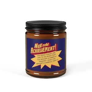 Op de afbeelding: Een kaars in een glazen pot met een zwart deksel. Op het etiket staat "NEE EEW ACHIEVEMENT!" met daaronder de tekst "YOU READ A BOOK AND LIKE TO SO MUCH THAT YOU BOUGHT A CANDLE! REWARD: I SAID YOU BOUGHT A CANDLE, THAT IT."