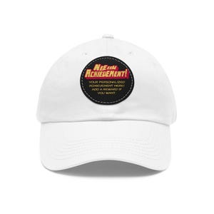 May include: White baseball cap with a curved brim. The cap features a circular patch with the text "NEEEE ACHIEVEMENT!" in red and yellow. Below, it reads "YOUR PERSONALIZED ACHIEVEMENT HERE! ADD A REWARD IF YOU WANT."
