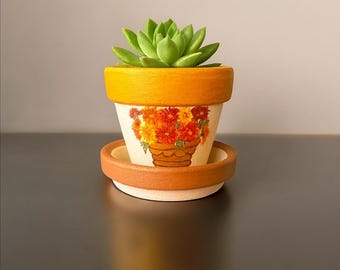 手描きのテラコッタ植木鉢と受け皿：秋の花飾り