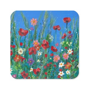 May include: Square coaster with a colourful floral painting. The artwork depicts red poppies, pink and white daisies, and purple flowers against a blue backdrop. Green grass and stems enhance the natural scene. A decorative item for home decor.