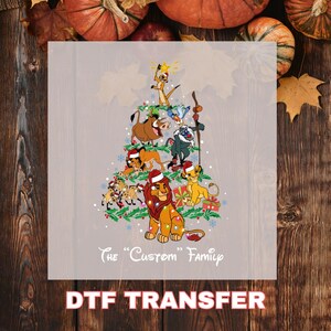 May include: A DTF transfer featuring a Christmas tree design composed of characters from The Lion King. The characters are wearing Santa hats and surrounded by Christmas lights and snowflakes. The text "The Custom Family" is below the tree.