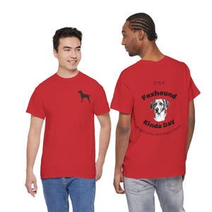 May include: Red t-shirts with a Foxhound theme. One shirt has a small black silhouette of a dog on the front. The other shirt has the text "IT'S A Foxhound Kinda Day" with a dog image and the words "wiggle butts and sloppy kisses."