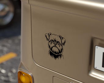 Peut inclure: Un autocollant noir et blanc représentant un chien Griffon Bruxellois, apposé à l'arrière d'un véhicule. L'autocollant présente une illustration détaillée du visage du chien, mettant en valeur ses traits distinctifs.