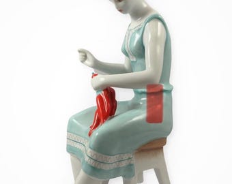 Vintage Hollohaza porcelain a woman sitting on a stool stringing paprika peppers