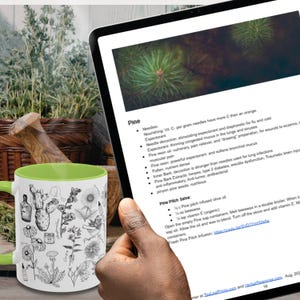 May include: A white ceramic mug with a black handle and the text "But First, Coffee" in a black, bold font. The mug is on a wooden surface. The mug is approximately 10 cm tall.