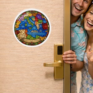 May include: A round, stained-glass style sticker featuring a map of the Mediterranean Sea and surrounding countries. The sticker has a white border and includes the text "William's Family Adventure". The map is colorful, with each country represented by a different color.