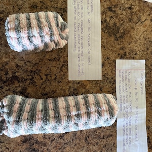 May include: Two handmade, striped ear and sinus compresses. The compresses are made of soft, plush fabric in shades of pink, gray, and white. Instructions for use are included on handwritten notes.